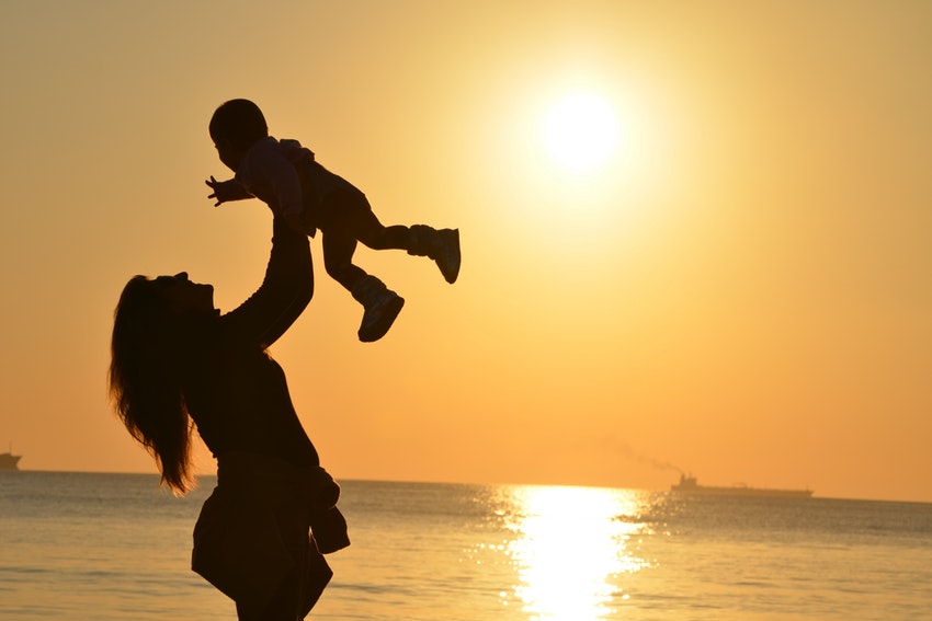 Une mère et un fils devant un coucher de soleil