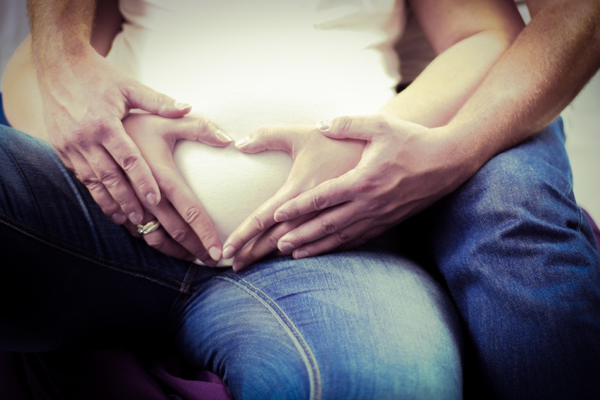Couple et grossesse, femme enceinte et son mari, les mains en coeur 